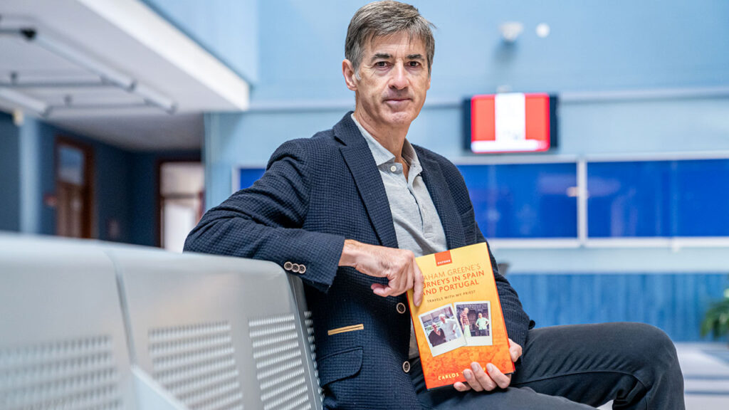 Carlos Villar Flor posa con un ejemplar de ‘Los viajes de Graham Greene por España y Portugal’ | Foto: UR