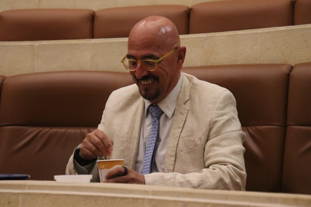 César Pascual, consejero de Salud, sentado en su escaño en el Parlamento de Cantabria.