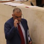 Roberto Media, consejero de Fomento, camina hacia la tribuna de oradores del Parlamento de Cantabria.