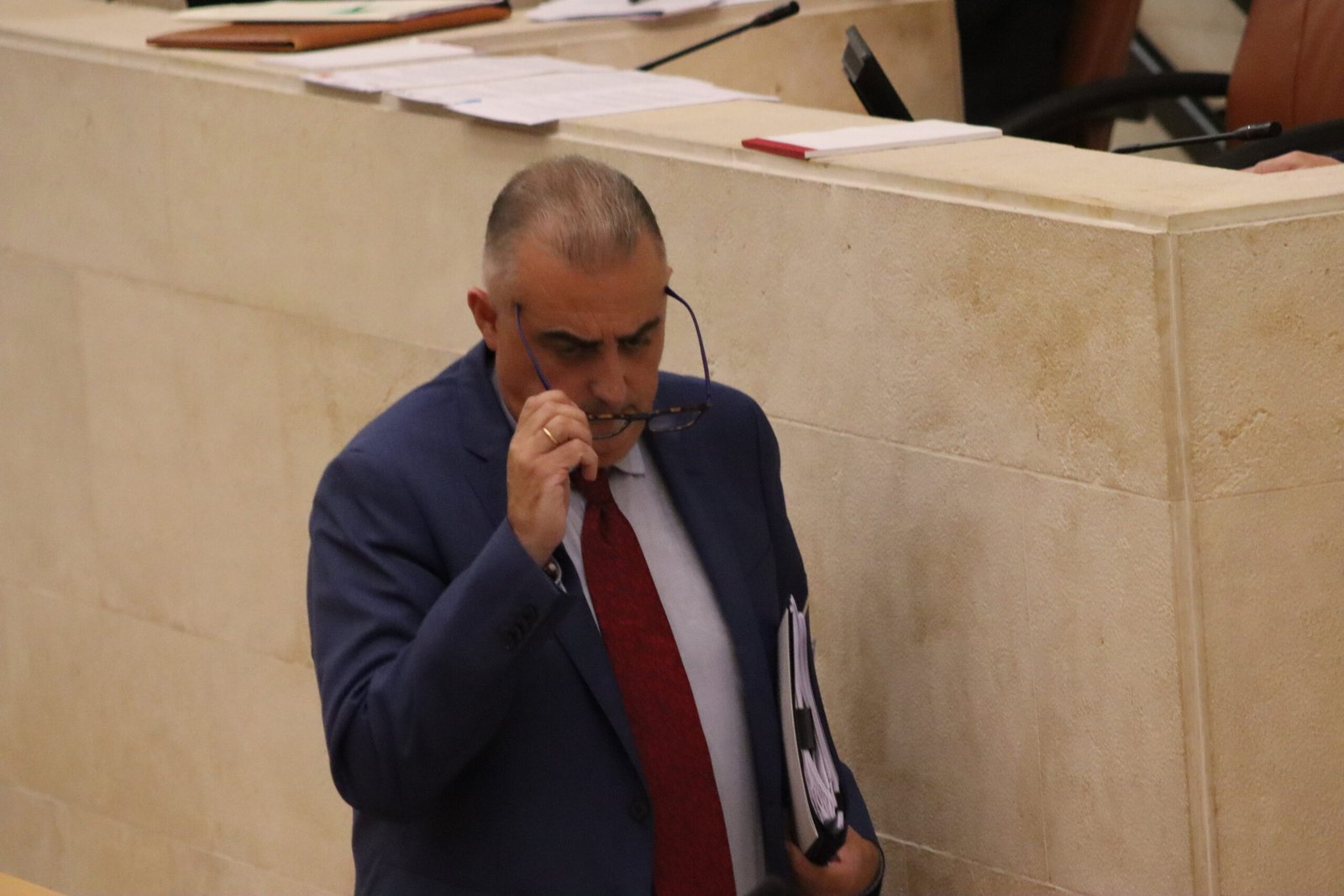 Roberto Media, consejero de Fomento, camina hacia la tribuna de oradores del Parlamento de Cantabria.