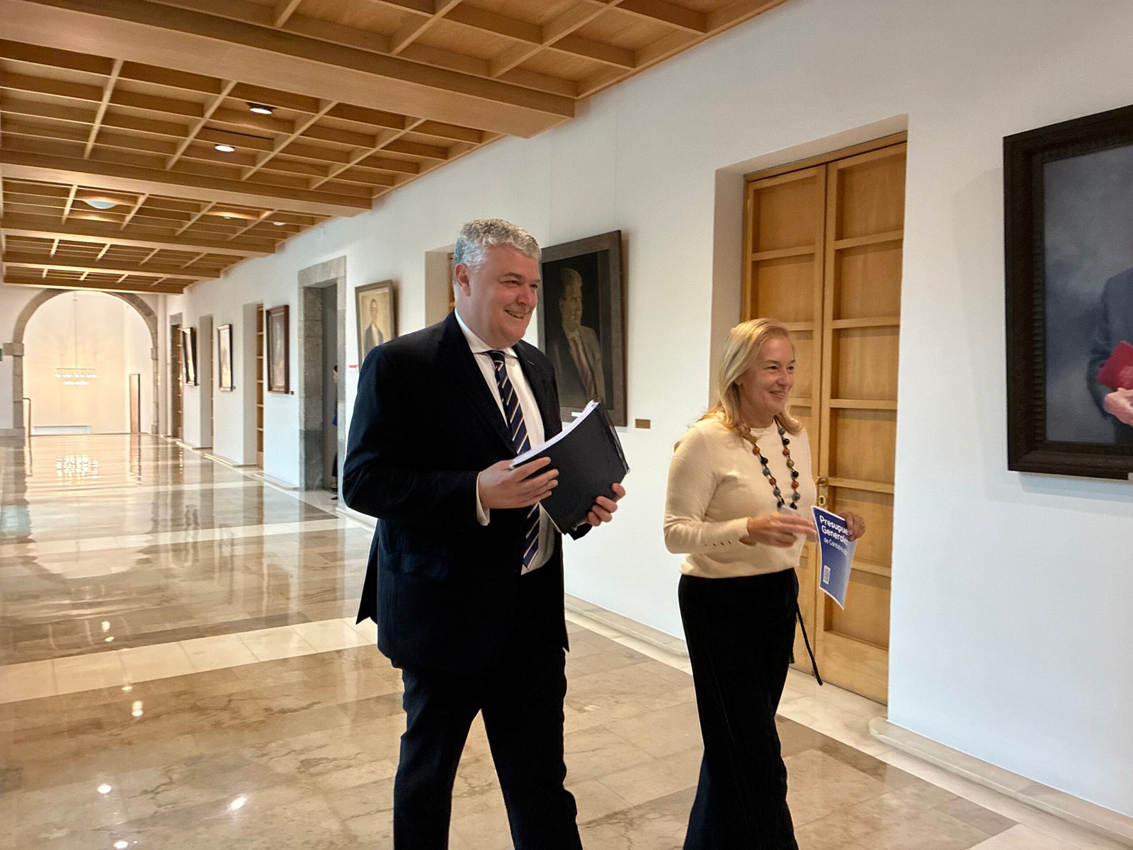 El consejero de Economía, Hacienda, Financiación Autonómica y Fondos Europeos, Luis Ángel Agüeros, junto a la presidenta del Parlamento de Cantabria, María José González Revuelta, durante la presentación de los Presupuestos de 2027