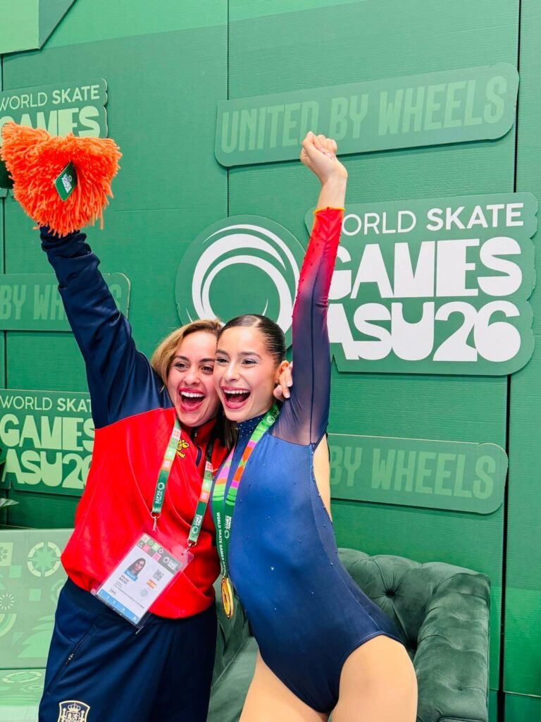 India González celebra la medalla de oro júnior de patinaje artístico en línea junto a su entrenadora en los World Skate Games de Paraguay.