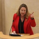 Leticia Díaz, portavoz de Vox, defiende desde la tribuna del Parlamento de Cantabria su moción para reforzar la seguridad en Ceuta y Melilla.