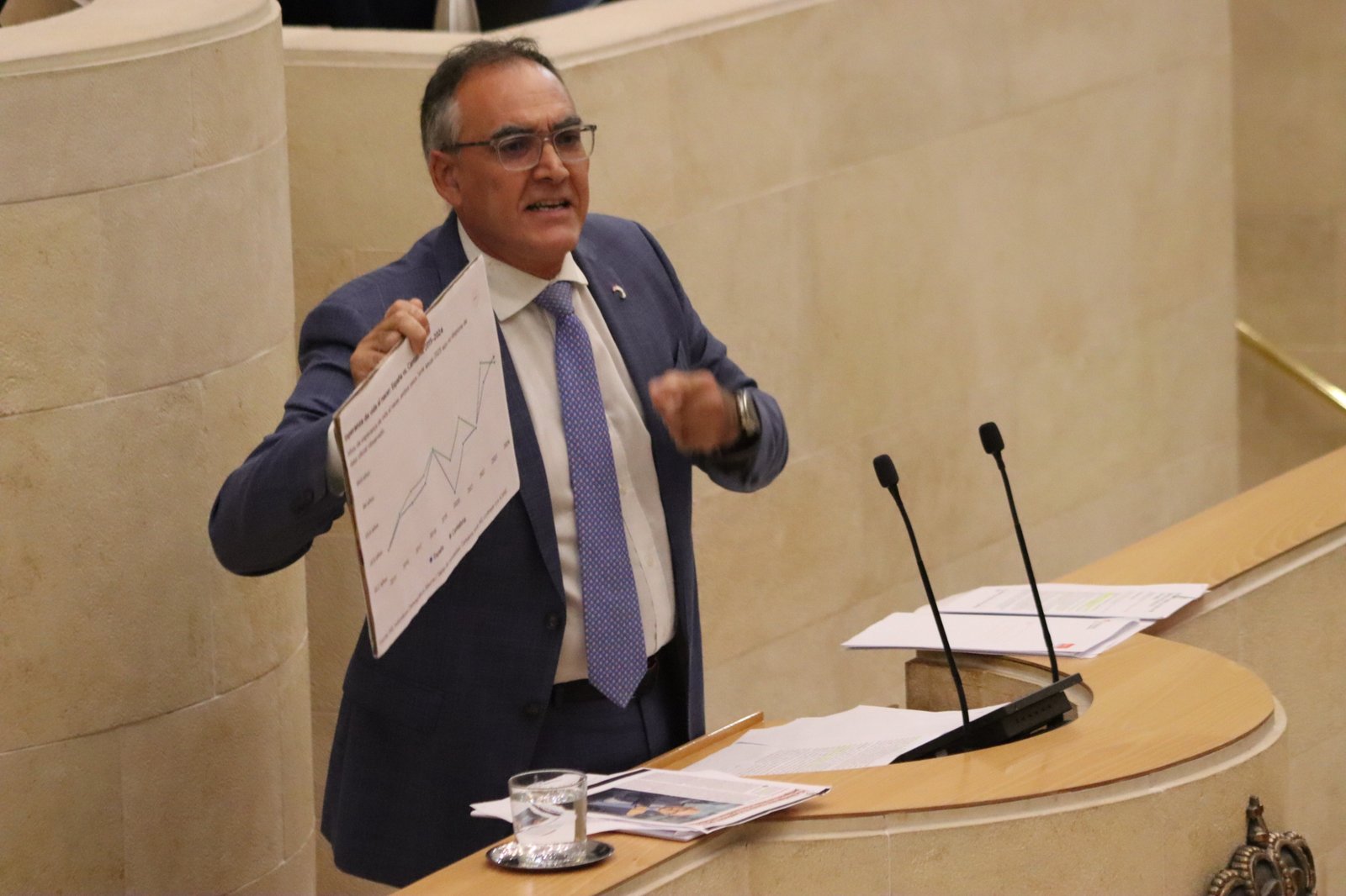 Raúl Pesquera muestra una estadística sobre la esperanza de vida desde la tribuna del Parlamento de Cantabria.
