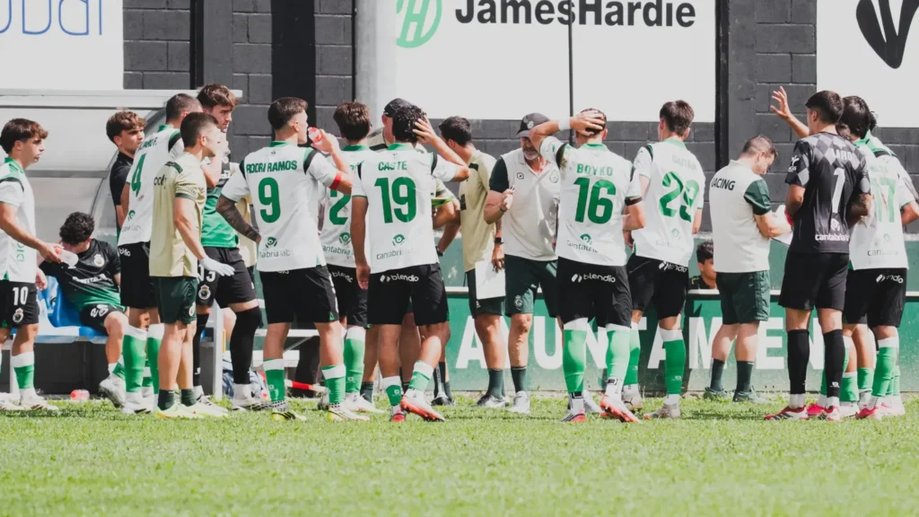 Los jugadores del Rayo Cantabria escuchan las instrucciones del entrenador durante un entrenamiento.